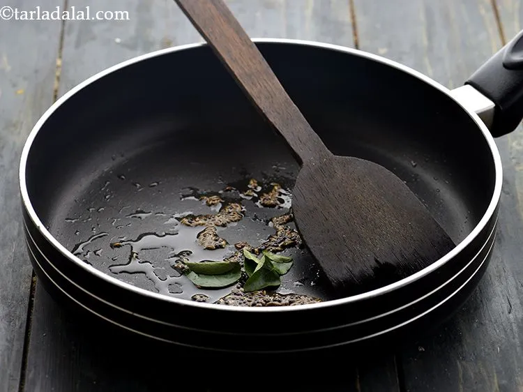 स्टेप 11 – जब बीज चटक जाए तो कढ़ी पत्ता डालें।