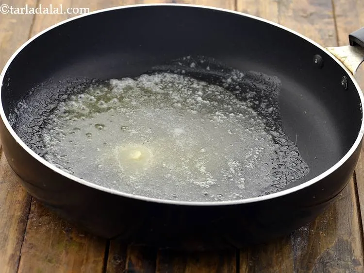 Step 34 – <strong>For the spinach layer</strong>, heat 1tbsp&nbsp;<a href="https://www.tarladalal.com/glossary-butter-makhan-233i">butter</a> in a broad non-stick pan.