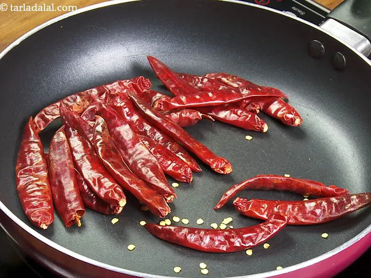 Step 14 – Add dry red chillies in the same pan. Remove the stalk and break them roughly …