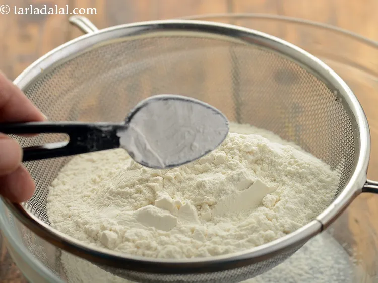 स्टेप 12 – १ टी-स्पून <a href=""https://www.tarladalal.com/glossary-baking-powder-hindi-425i"">बेकिंग पाउडर</a> डालें।