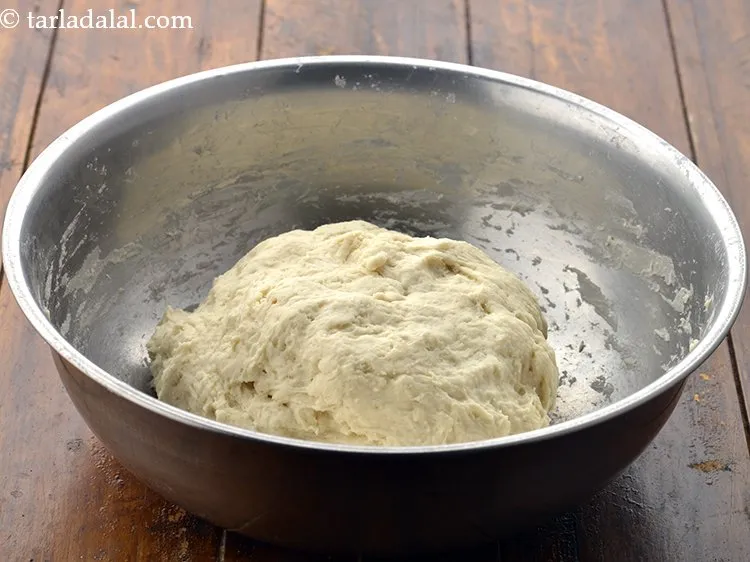 स्टेप 16 – लगभग १ कप गर्म पानी का प्रयोग करके नरम आटा …