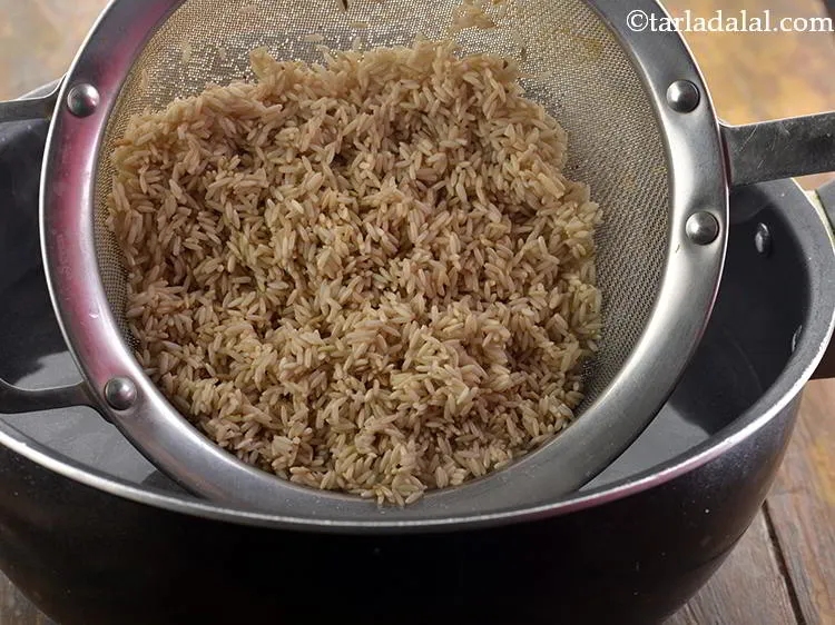 स्टेप 13 – इस पानी में ब्राउन राइस डालकर, अच्छी तरह मिलाएँ।