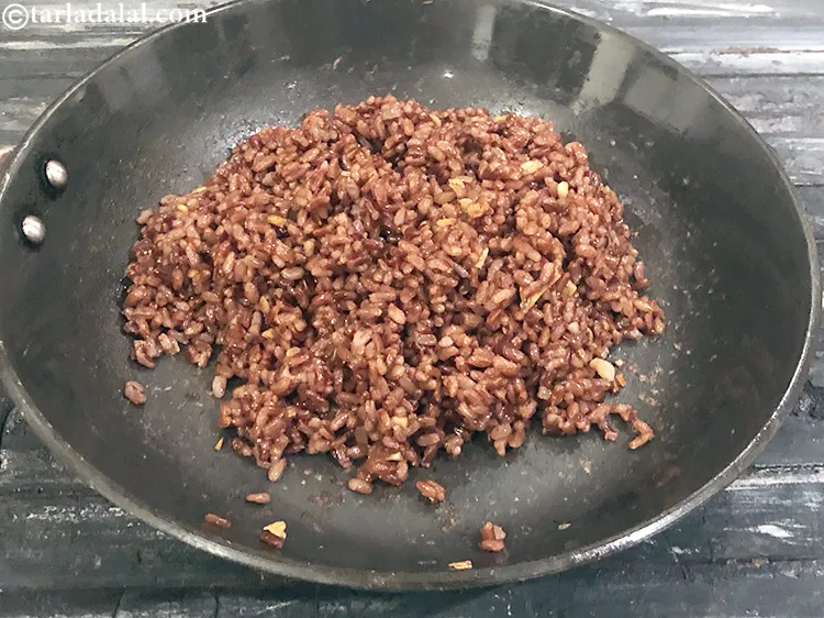 Step 14 – Mix the<strong>&nbsp;simple red rice with garlic</strong>&nbsp;well and cook on a medium flame for 1 minute.