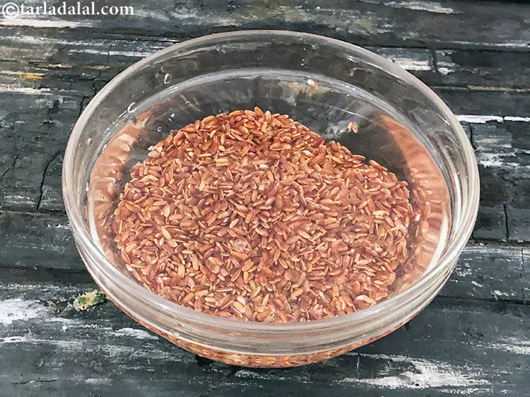 Step 3 – Clean and wash red rice with water. Drain the water using a sieve.&nbsp;