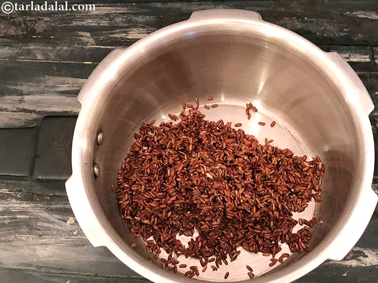 Step 4 – Add the washed red rice in a pressure cooker.