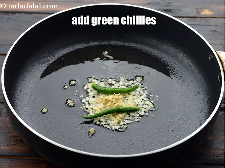 Step 29 – Add 2&nbsp;<a href="https://www.tarladalal.com/glossary-slit-green-chillies-1856i">slit green chillies</a>.
