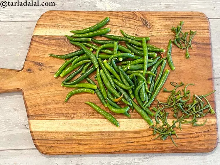 Step 2 – Cut the stems of the green chillies and discard them.