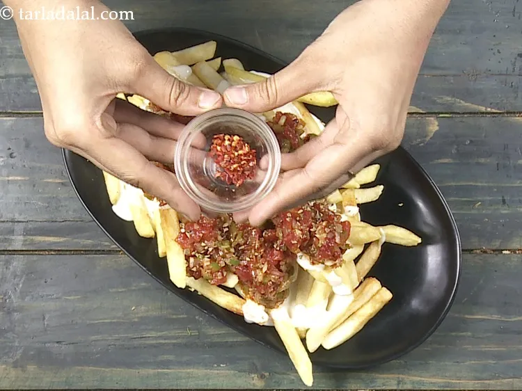 Step 31 – Top it with 1/4 tsp&nbsp;<a href="https://www.tarladalal.com/glossary-dry-red-chilli-flakes-paprika-338i">dry red chilli flakes (paprika)</a>.