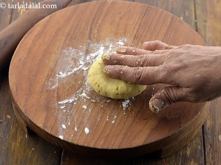 Step 11 – Take a portion of the dough and flatten it on the rolling board.