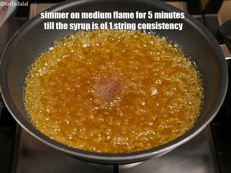 Step 7 – Simmer on medium flame for 5 minutes till the syrup is of 1 string consistency.