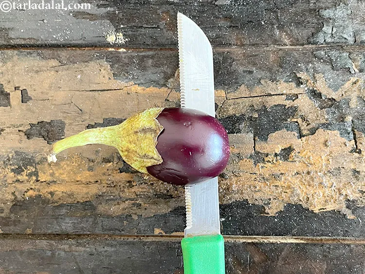 Step 23 – Slit the brinjal sideways to half length of the brinjal.
