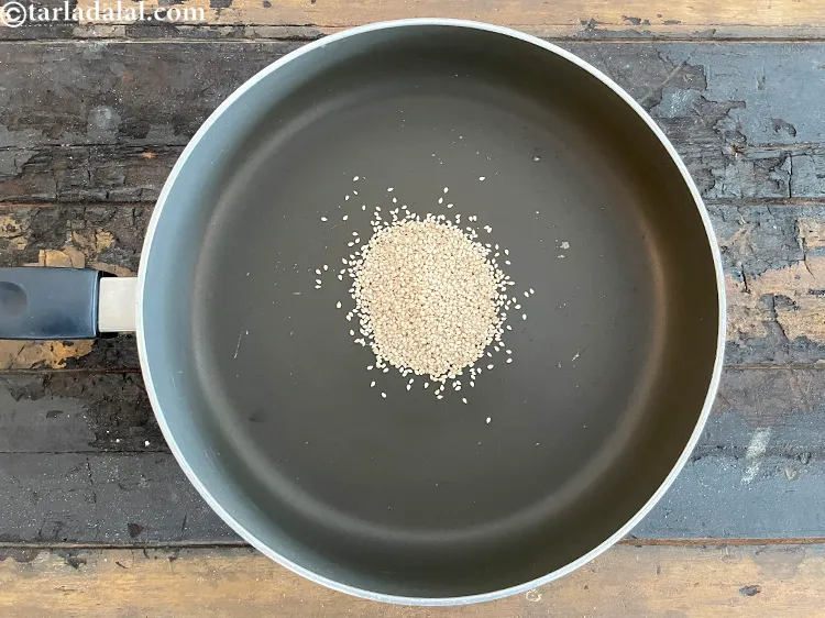 Step 7 – In a broad non-stick pan put&nbsp;<meta charset="UTF-8" />2 tbsp&nbsp;<a href="glossary-sesame-seeds-til-gingelly-seeds-612i">sesame seeds (til)</a>.