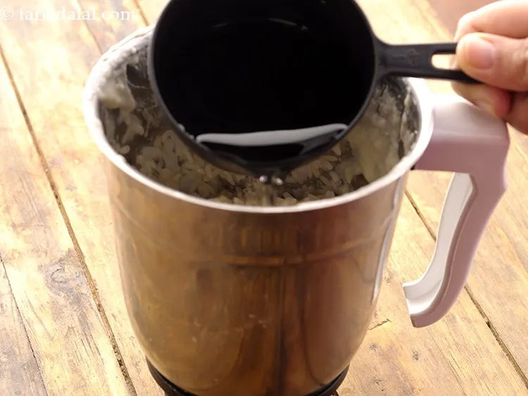 स्टेप 29 – मिक्सर जार में लगभग १ १/२ कप पानी डालें। घोल …