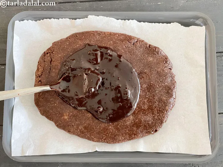 Step 21 – Take a spoon and spread some of the melted chocolate on top of the base.