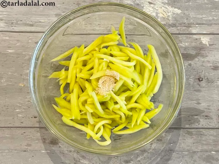 Step 12 – In a deep bowl add&nbsp;<meta charset="UTF-8" />1/2 tsp&nbsp;<a href="glossary-asafoetida-hing-113i">asafoetida (hing)</a>&nbsp;to the raw mangoes.