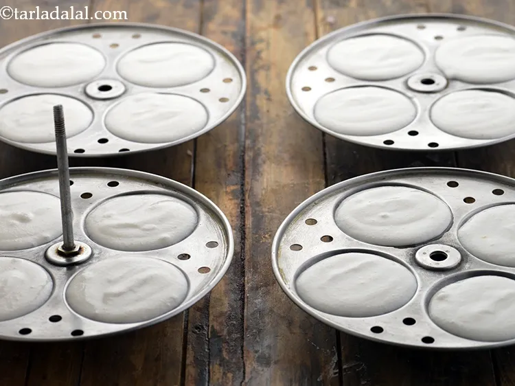 Step 24 – Put spoonfuls of batter into greased idli moulds. Do not overfill as the aval idlis …