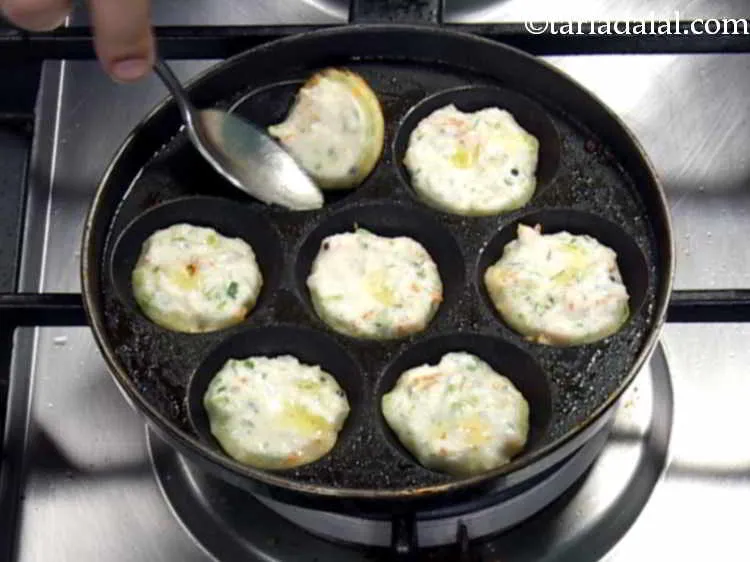 Step 17 – Turn each <strong>rava appe</strong> upside down using a fork so as to cook them from …