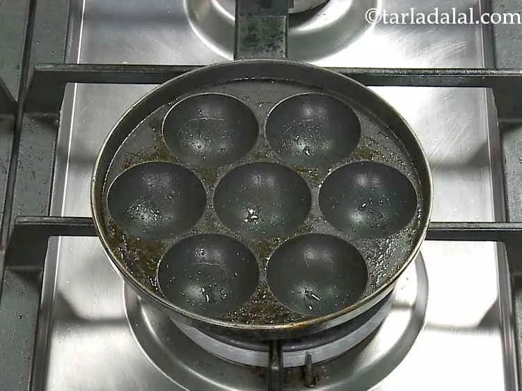 Step 14 – Heat the appe mould on a medium flame and grease it using &frac12; tsp of …