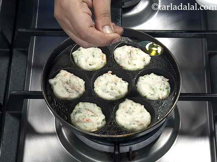 Step 16 – Cook<strong> rava appe</strong> using &frac12; tsp of oil till the lower surface becomes golden brown.