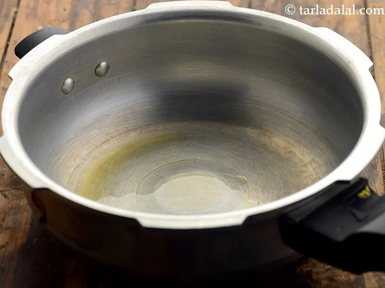 Step 5 – Next heat 1/2 tsp&nbsp;<a href="https://www.tarladalal.com/glossary-ghee-245i">ghee</a>&nbsp;in a pressure cooker.