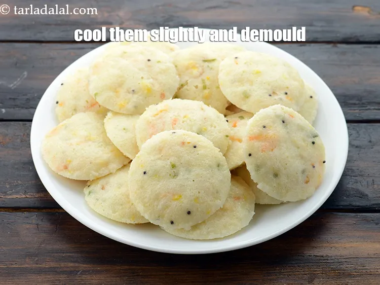 Step 35 – Once the idlis are cooked, cool them slightly. Dip a spoon in the water and …