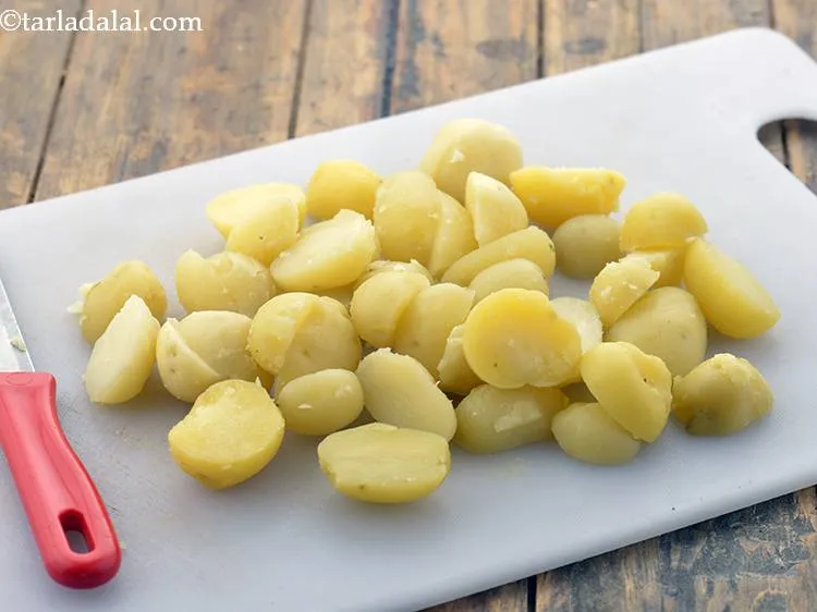 स्टेप 4 – एक तेज चाकू का उपयोग करके बेबी पोटैटो को आधा …