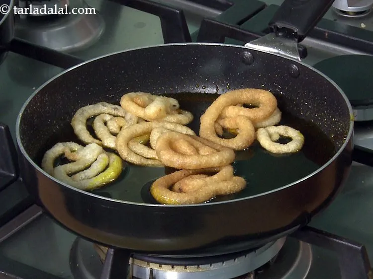 Step 26 – Place the <strong>fried halwai style Indian jalebi</strong> into the warm sugar syrup. If the sugar …