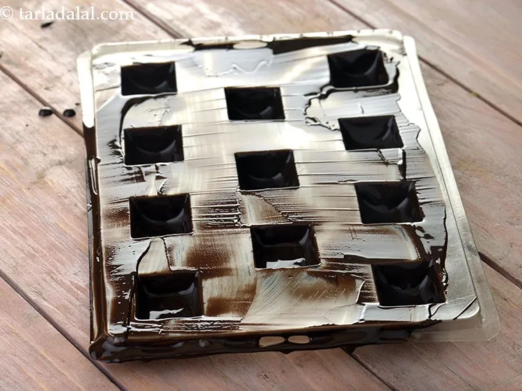 Step 28 – Clean the upper surface of the chocolate mould using a palette knife across the chocolate …