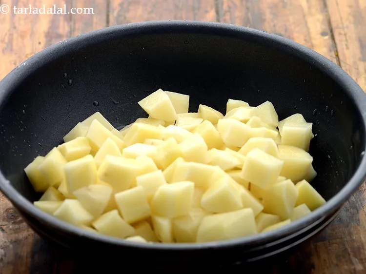 Step 5 – When the seeds crackle, add potatoes.