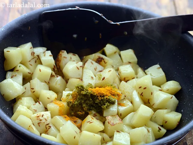 Step 9 – Add turmeric powder. Those who are fasting can skip turmeric to relish <strong>jeera aloo</strong>.&nbsp;