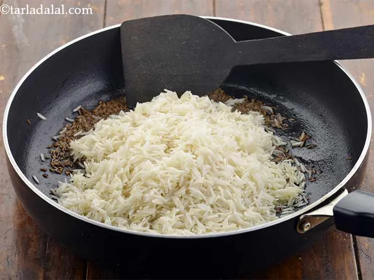 Step 11 – Once the seeds crackle, add the rice.