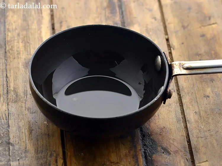 Step 12 – For the tempering of <strong>healthy jowar khichdi</strong>, heat 2 tsp&nbsp;<a href="https://www.tarladalal.com/glossary-ghee-245i">ghee</a> in a small non-stick …