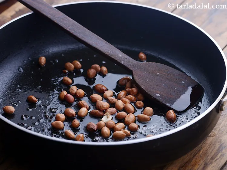 Step 6 – When the seeds crackle, add the peanuts.
