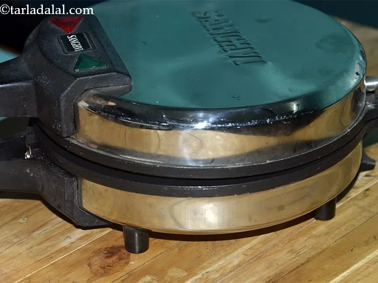 Step 33 – Meanwhile also pre-heat a khakhra maker. This may take around 2 to 3 minutes.&nbsp;