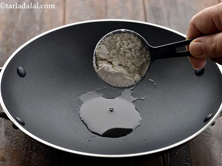 Step 11 – As the ghee melts, add jowar flour to it.&nbsp;