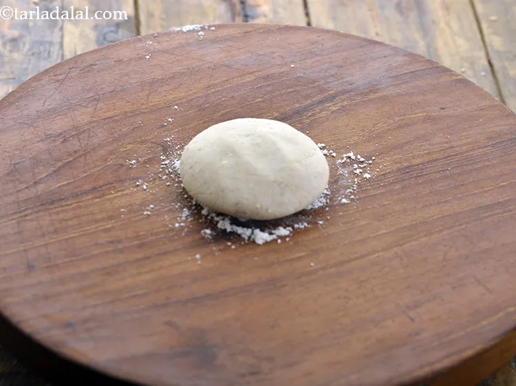 Step 14 – Take a portion the dough of <strong>healthy jowar bhakri</strong>, flatten it slightly and place it …