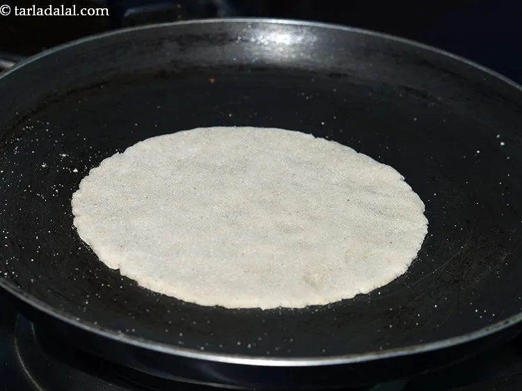Step 16 – Heat a non-stick tava (griddle) on a medium flame and when hot, place the <strong>jwarichi …