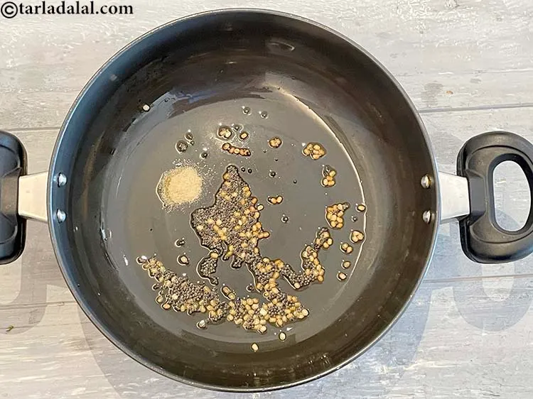 Step 4 – When the mustard seeds crackle, add the asafoetida.