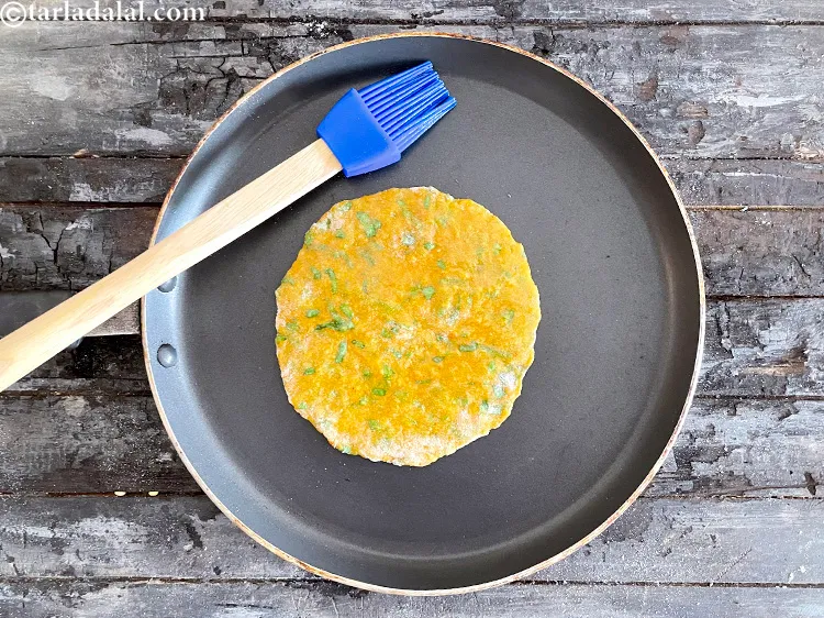 Step 26 – Brush the uncooked top part of the roti with a little oil.&nbsp;