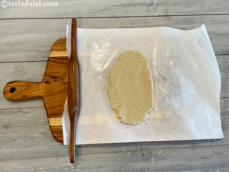 Step 18 – Cover the mixture with the butter paper and roll it out with a belan.&nbsp;