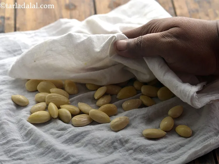 Step 7 – Spread the deskinned almonds on a muslin cloth. Dab them very well with the same …