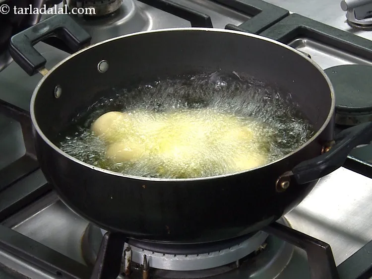 Step 19 – Add 10 jamuns at a time in it. Ensure that the ghee is hot enough, …