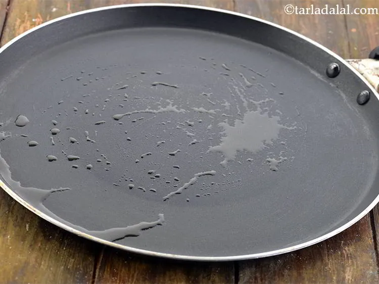 स्टेप 10 – एक नॉन-स्टिक तवा गरम करें और १/२ टी-स्पून घी लगाकर …