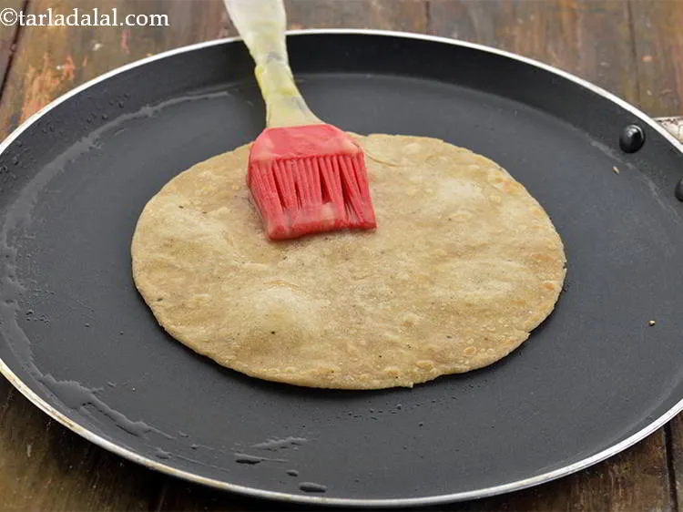 स्टेप 12 – १ टी-स्पून घी लगाकर एक तरफ से सुनहरा भूरा होने …