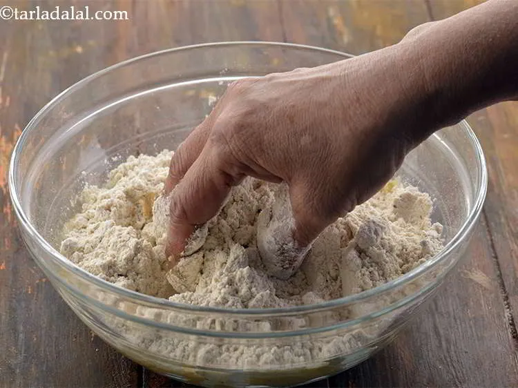 स्टेप 5 – आटे को अपने हाथों से अच्छी तरह मिलाएं।