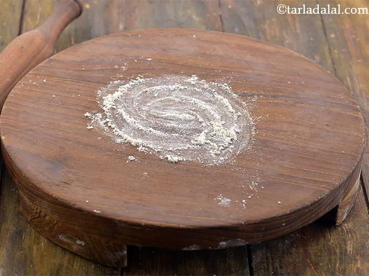 स्टेप 8 – <div> रोलिंग की सतह पर थोड़ा सुखा गेहूं का आटा …