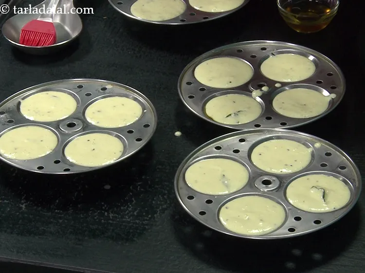 Step 51 – Pour spoonfuls of the batter into each of the greased idli moulds.