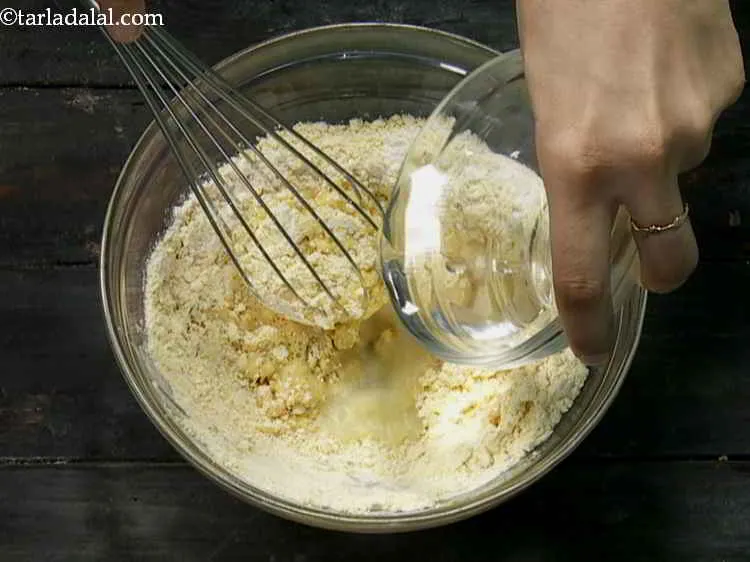 Step 7 – Gradually add water to the flour while mixing continuously with a whisk.