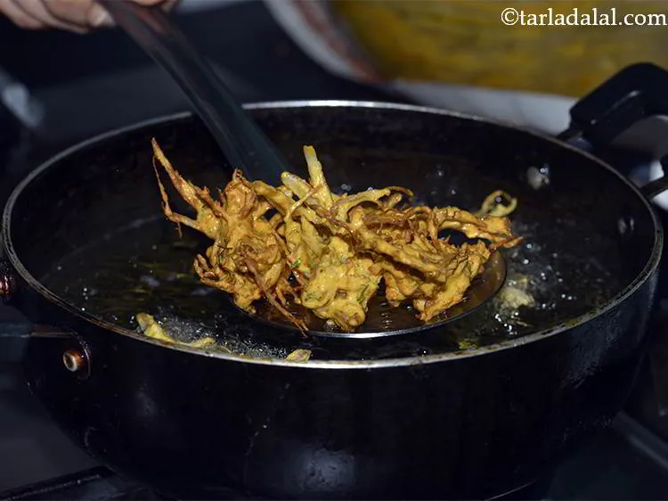 Step 18 – When the&nbsp;<strong>Kanda Bhaji</strong>&nbsp;<strong>&nbsp;(Pyaz ke Pakode)</strong>&nbsp;have turned light brown in color from one side, gently flip …