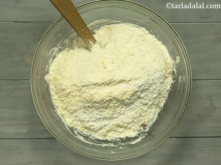 स्टेप 15 – इसमें मैदा-कस्टर्ड पाउडर का मिश्रण डालें।